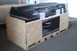 Holzkiste auf Palette, zum Versand mit schwarzer Plastikfolie umwickelt